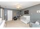 This bedroom has grey walls, carpet flooring, and a white crib, ceiling fan, and accent chair at 15885 Symphony Blvd, Noblesville, IN 46060