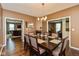Open-concept dining area with hardwood floors, chandelier, and seating for six, perfect for entertaining at 15885 Symphony Blvd, Noblesville, IN 46060
