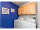 Convenient laundry room featuring a washer, dryer, storage cabinets, and charming decor at 15885 Symphony Blvd, Noblesville, IN 46060