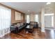 Comfortable living room with hardwood floors, two black couches, and two large windows with curtains at 15885 Symphony Blvd, Noblesville, IN 46060