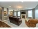 Cozy living room with a fireplace and dark brown leather couches in an open concept layout at 15885 Symphony Blvd, Noblesville, IN 46060