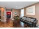 Inviting living room features hardwood floors, comfortable seating, and soft natural light from large windows at 15885 Symphony Blvd, Noblesville, IN 46060