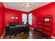 Bright office features red walls, dual monitors, a ceiling fan, and ample shelving for organization at 15885 Symphony Blvd, Noblesville, IN 46060