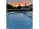 Sparkling blue pool against a dramatic sunset, offering a tranquil backyard retreat at 15885 Symphony Blvd, Noblesville, IN 46060