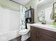 Modern bathroom features a bathtub with shower, a dark vanity and leafy design elements at 1683 Sweetwater Ln, Greenfield, IN 46140