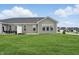 Spacious backyard with lush green grass, featuring a gray house and an outdoor dining set at 16955 Cole Evans Dr, Noblesville, IN 46060
