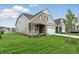 Wide shot of the gray home from across the lawn, showing architectural details and landscaping at 16955 Cole Evans Dr, Noblesville, IN 46060