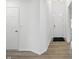 Bright hallway with hardwood floors, white walls, and a view of the front door at 16955 Cole Evans Dr, Noblesville, IN 46060