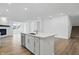 Modern kitchen with an island, stainless steel dishwasher, white cabinets, and hardwood floors at 16955 Cole Evans Dr, Noblesville, IN 46060