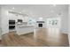 Open-concept kitchen with white cabinets, stainless steel appliances, and a center island, flowing into the living space at 16955 Cole Evans Dr, Noblesville, IN 46060