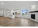 Open-concept living area with a fireplace, hardwood floors, and modern kitchen at 16955 Cole Evans Dr, Noblesville, IN 46060