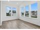 Sunlit room with multiple windows offering neighborhood views, hardwood floors, and bright ambiance at 16955 Cole Evans Dr, Noblesville, IN 46060
