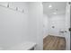 Mud room with a bench, hooks, and tile flooring, leading into the laundry room at 16955 Cole Evans Dr, Noblesville, IN 46060
