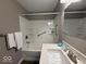 Well-lit bathroom showcasing a clean tub/shower with grab bar and white shower surround at 2406 E 10Th St, Anderson, IN 46012