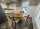 Cozy dining area with round wood table, four chairs, wood floors, and abundant natural light at 2406 E 10Th St, Anderson, IN 46012
