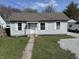 Charming bungalow-style home featuring light blue siding, white trim, and a well-manicured lawn at 2406 E 10Th St, Anderson, IN 46012