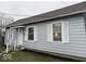 Charming bungalow-style home featuring light blue siding, white trim, and an attractive lawn at 2406 E 10Th St, Anderson, IN 46012