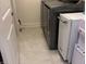 Functional laundry area with tile flooring, modern washer and dryer units, and a convenient water dispenser at 2460 Collins Dr, Westfield, IN 46074