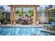 Gorgeous pool-side patio area complete with a pergola, hanging plants, and comfortable seating for entertaining at 2460 Collins Dr, Westfield, IN 46074