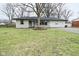Charming ranch-style home featuring stone accents, black trim, and a well-maintained lawn at 2750 Kristen E Dr, Indianapolis, IN 46218