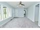 Bright living room with large windows, new gray carpet, and a ceiling fan for added comfort at 2750 Kristen E Dr, Indianapolis, IN 46218