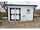 Neat white storage shed with black trim and double doors provides ample outdoor storage solutions at 2750 Kristen E Dr, Indianapolis, IN 46218