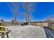 Large gravel backyard and fence with mature trees and an SUV parked on the parking pad at 3006 W 10Th St, Indianapolis, IN 46222