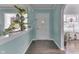 A bright foyer with beautiful teal walls, a view of a plant atrium, and stained-glass windows at 319 Alice St, Shelbyville, IN 46176