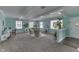 Spacious living room with bright teal walls, carpeted floors, and views of a plant atrium at 319 Alice St, Shelbyville, IN 46176