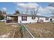 Exterior view of back of home and partially fenced yard with mature trees at 33 W Mill St, New Palestine, IN 46163