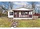 A cozy one-story house featuring a covered porch with burgundy trim and a stepping stone path at 33 W Mill St, New Palestine, IN 46163