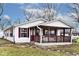 Charming home featuring a covered front porch with burgundy trim and a well-manicured lawn at 33 W Mill St, New Palestine, IN 46163