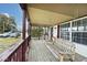 Inviting covered front porch features a swing, burgundy trim, and view of the front yard at 33 W Mill St, New Palestine, IN 46163