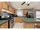 Well-lit kitchen with wood cabinets, black appliances, mosaic backsplash, and ample counter space at 33 W Mill St, New Palestine, IN 46163