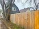 View of the side and backyard with a wood fence near the home and trees at 3315 E Vermont St, Indianapolis, IN 46201