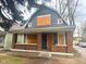 Two-story home with brick accents on the porch columns and boarded windows on a cloudy day at 3315 E Vermont St, Indianapolis, IN 46201