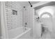 Bright bathroom with subway tile, modern fixtures, and an arched window above the toilet and vanity at 3447 Washington Blvd, Indianapolis, IN 46205