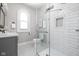 Modern bathroom featuring white tile shower and floor, vanity with drawers, and arched window at 3447 Washington Blvd, Indianapolis, IN 46205