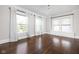 Bright bedroom with three large windows and hardwood flooring providing ample natural light at 3447 Washington Blvd, Indianapolis, IN 46205