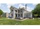A manicured lawn frames a beautiful home, showcasing elegant columns, lush landscaping and a serene outdoor space at 3447 Washington Blvd, Indianapolis, IN 46205