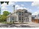 Charming three story home with detailed trim, a balcony, professional landscaping, and mature trees at 3447 Washington Blvd, Indianapolis, IN 46205