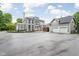 Expansive exterior view with a multi-story home, sunroom, deck, two-car garage, and generous driveway space at 3447 Washington Blvd, Indianapolis, IN 46205