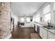Open kitchen featuring brick wall, granite countertops, stainless steel appliances and hardwood floors at 3447 Washington Blvd, Indianapolis, IN 46205