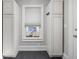 Mudroom with dark tile floors, white cabinetry, coat hooks and a window with cellular shades at 3447 Washington Blvd, Indianapolis, IN 46205