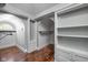 Well-organized walk-in closet with custom shelving, storage, and a unique arched window for natural light at 3447 Washington Blvd, Indianapolis, IN 46205