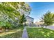Spacious backyard with green grass, mature trees, and a two-story home in the background at 3470 N Kenwood Ave, Indianapolis, IN 46208