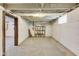 View of the unfinished basement showing painted walls and concrete floor, with a storage shelf unit at 3470 N Kenwood Ave, Indianapolis, IN 46208