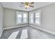 Sun-lit bedroom with gray carpet and walls featuring a ceiling fan and bright natural light at 3470 N Kenwood Ave, Indianapolis, IN 46208