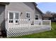 Back porch with white wooden railings and door to the house, surrounded by green grass at 3513 Berkdale Dr, Columbus, IN 47203