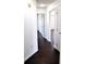 Long hallway with dark hardwood flooring, white walls and multiple doorways at 3513 Berkdale Dr, Columbus, IN 47203
